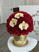 Gold and rose arrangement in a round box