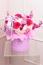 Maribel arrangement of pink flowers in a round box