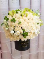 Round box filled with white and cream roses