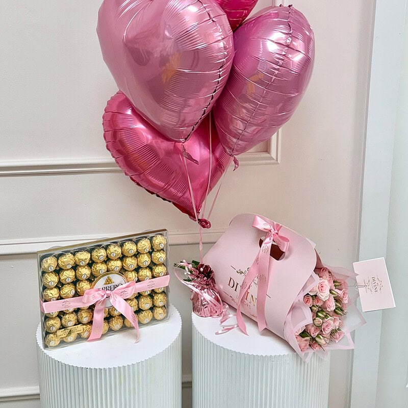 Globos de corazón rosa, chocolates Ferrero y ramo de mini rosas rosadas
