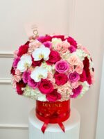Camila red hat box with pink and red roses and white orchids, photographed in our flower shop in Doral