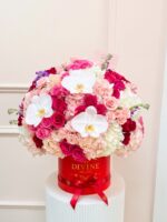 Camila: red My Divine Decors hat box with hot pink, red and blush roses, hydrangea and white orchids