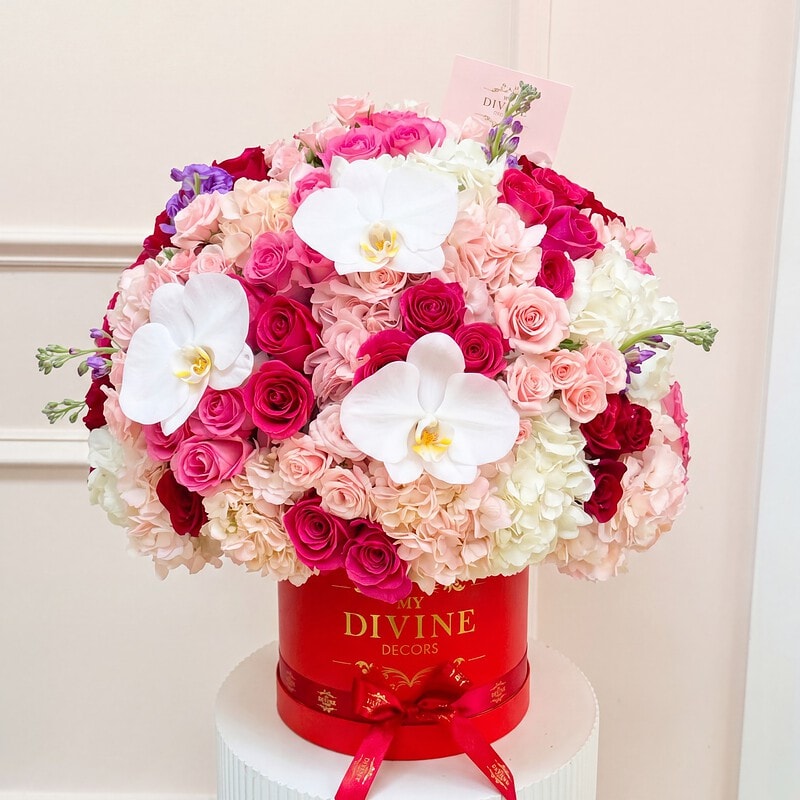 Camila: red My Divine Decors hat box with hot pink, red and blush roses, hydrangea and white orchids