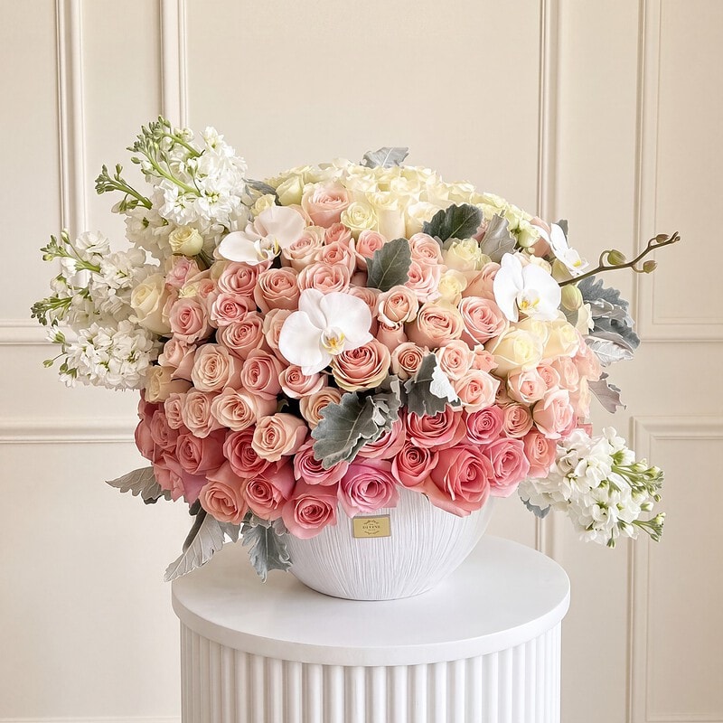 Lovely en florero XL: rosas durazno y crema, alhelí blanco y orquídeas en florero blanco