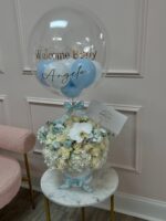 Caja Welcome Baby con rosas marfil, hortensia celeste, orquídea blanca y globo burbuja
