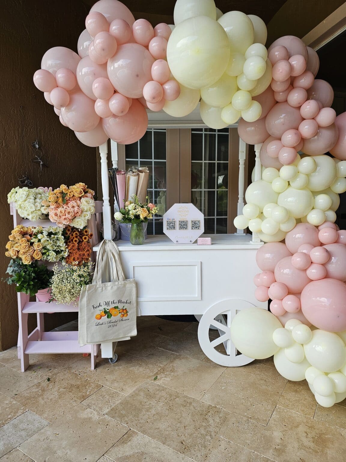 Carrito del flower bar de My Divine Decors con arco de globos rosados