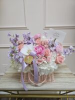 Basket of pastel flowers in pink and cream tones