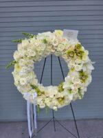Ivory wreath of white flowers on a display easel