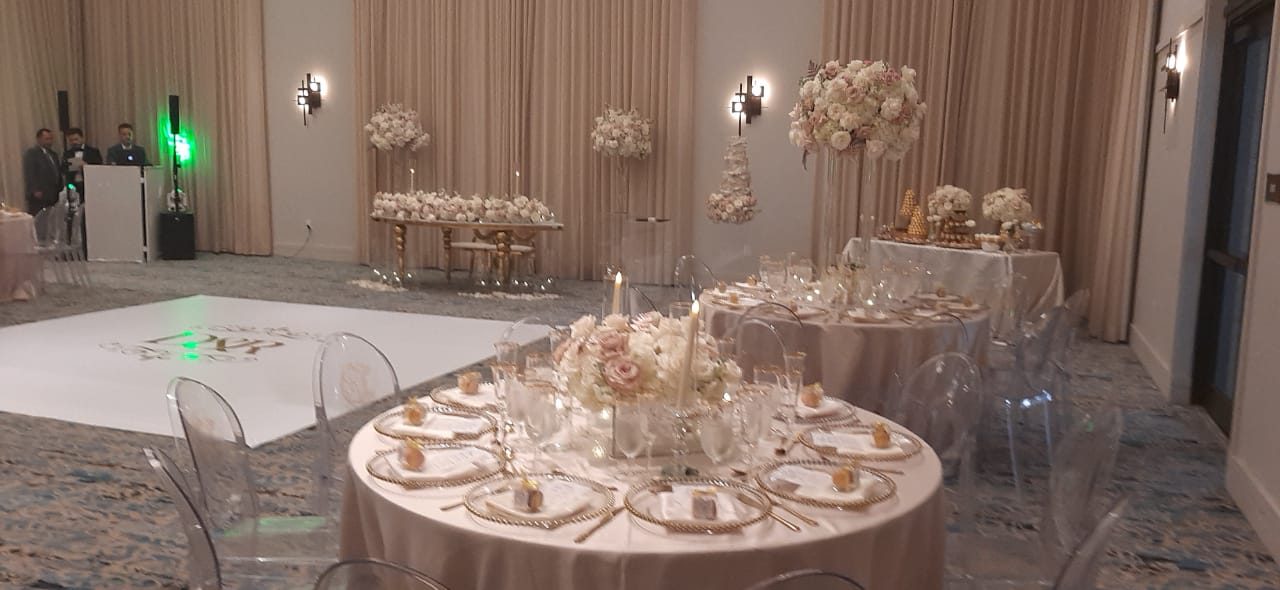 Recepción de boda con centros de mesa altos de flores blancas en un salón de Miami