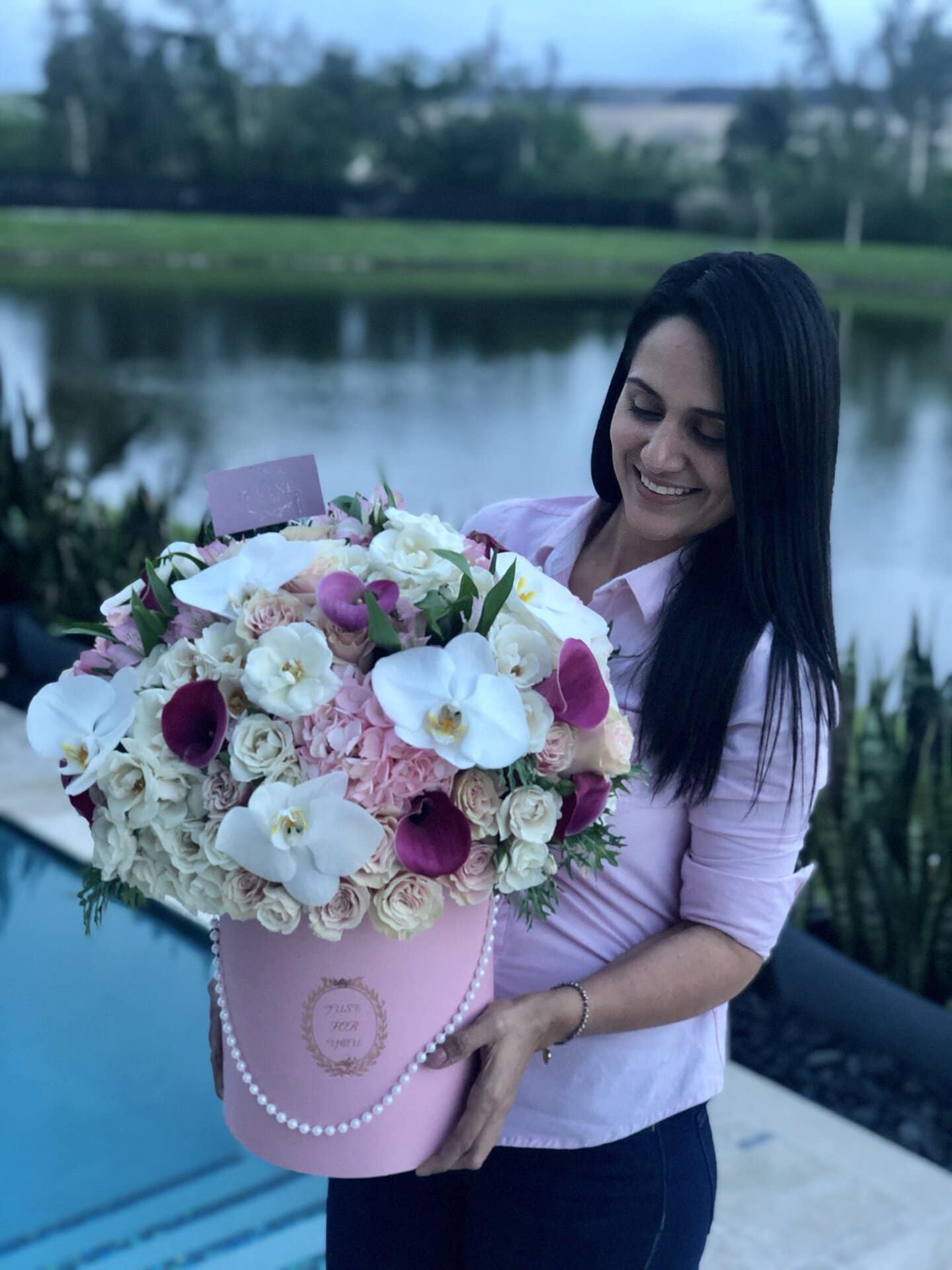 Jessica Nunez, fundadora de My Divine Decors, con una caja de flores rosada de lujo
