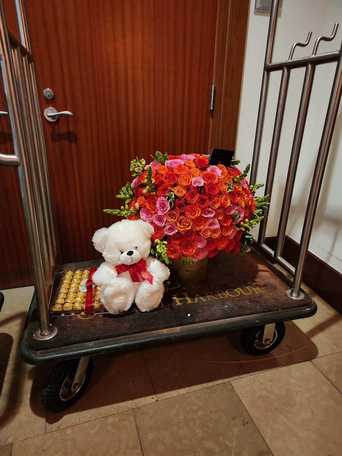 Teddy bear and roses arrangement on a luggage cart during a hotel delivery in Miami