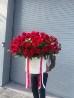 Oversized white box filled with about 100 red roses and greenery