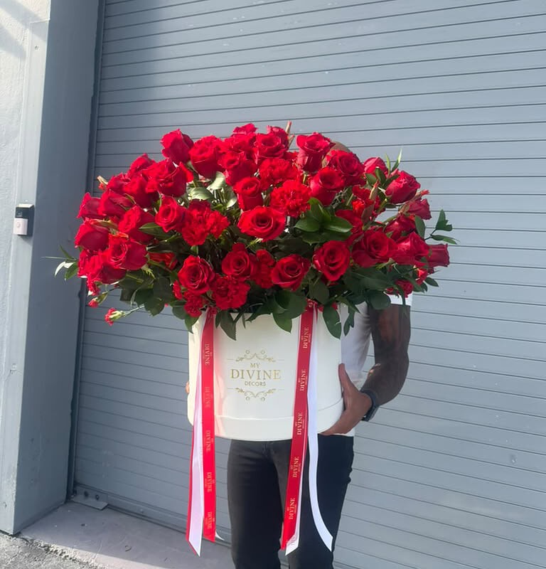 Oversized white box filled with about 100 red roses and greenery