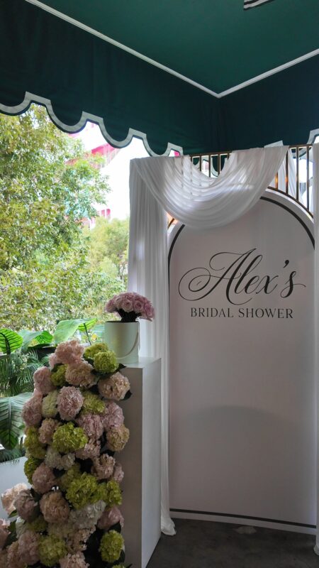 Backdrop en arco con cortina y columnas de hortensias rosadas y verdes para una despedida de soltera en Contessa Miami