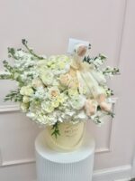 Cream and ivory flower hat box with a plush goose and pearl detail