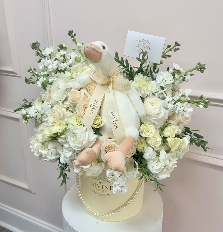 Side view of the buttercream blooms hat box with plush goose