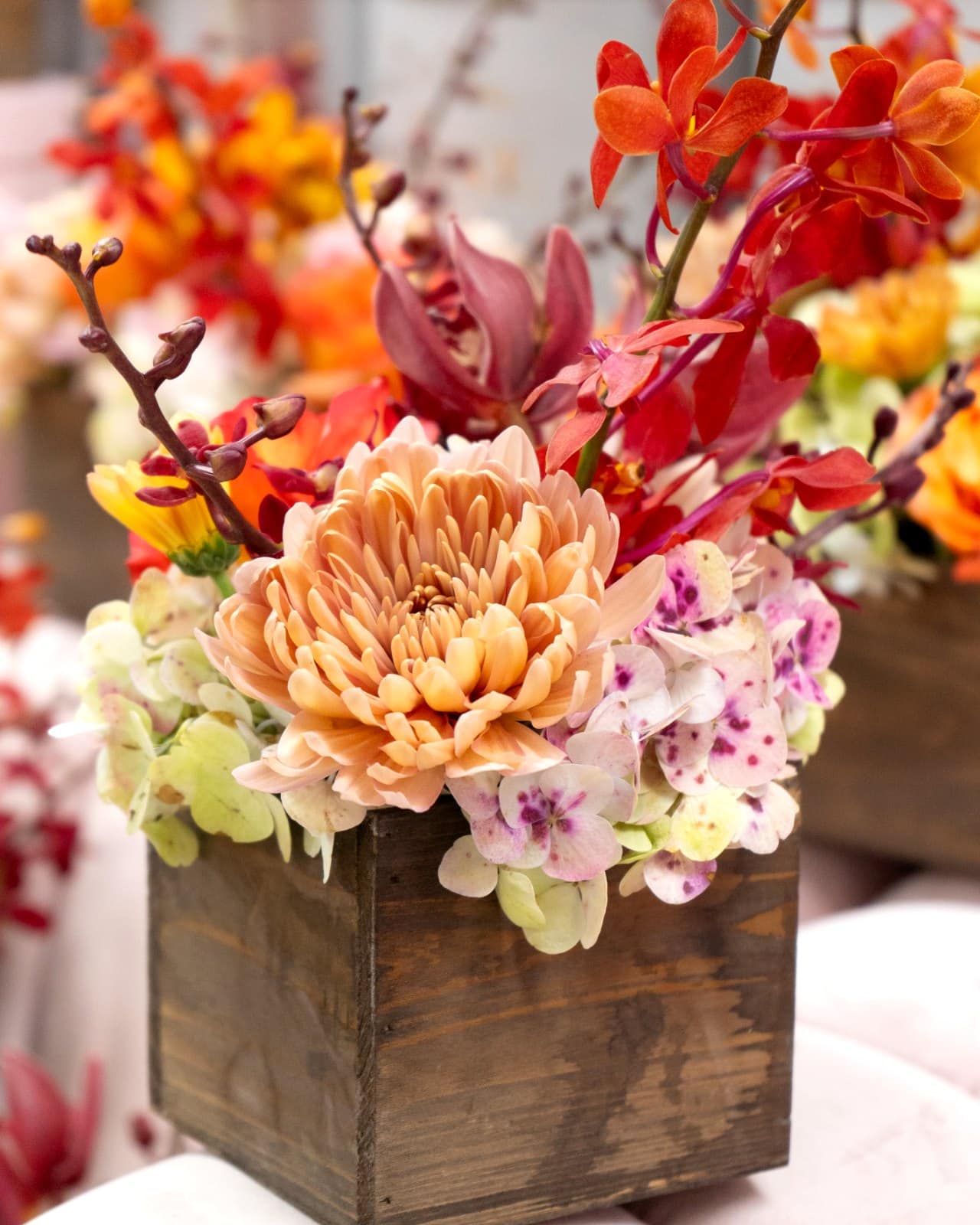 Centro de mesa de otoño en caja de madera con rosas melocotón, orquídeas y hortensias de My Divine Decors