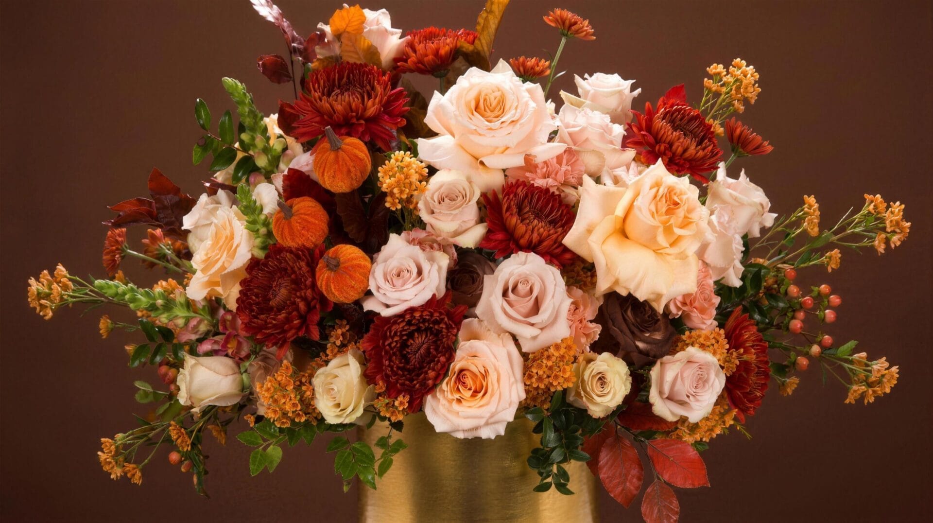Fall flower arrangement with champagne roses, burgundy mums and velvet pumpkins in a gold vase by My Divine Decors