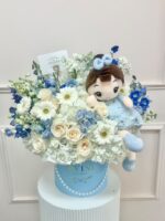 Blue hat box of white and blue fresh flowers with a plush doll