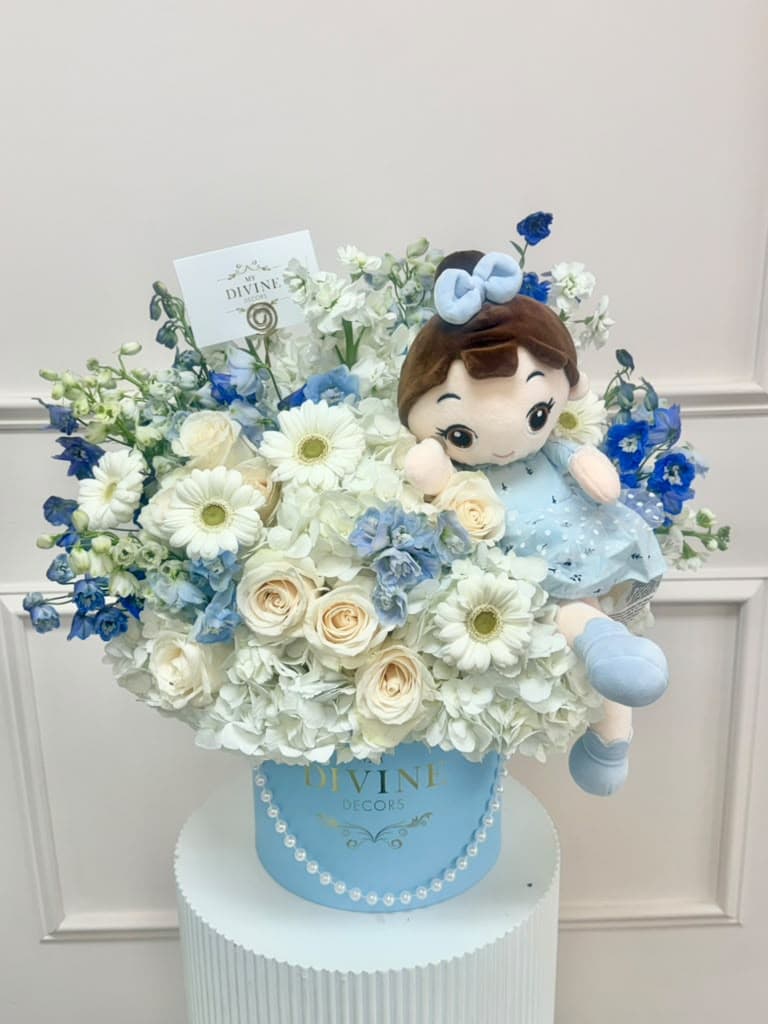Adorable Floral Hat Box with Plush Doll Blue hat box of white and blue fresh flowers with a plush doll