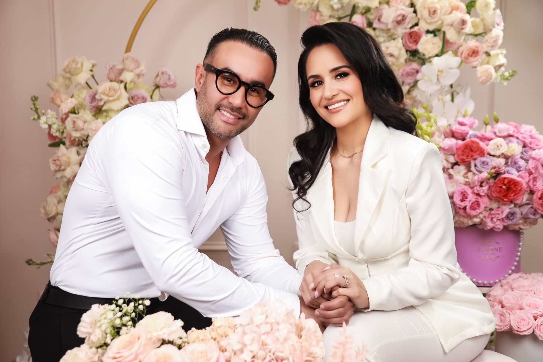 Jessica y Nelson, fundadores de My Divine Decors, tomados de la mano entre flores en su taller de Doral