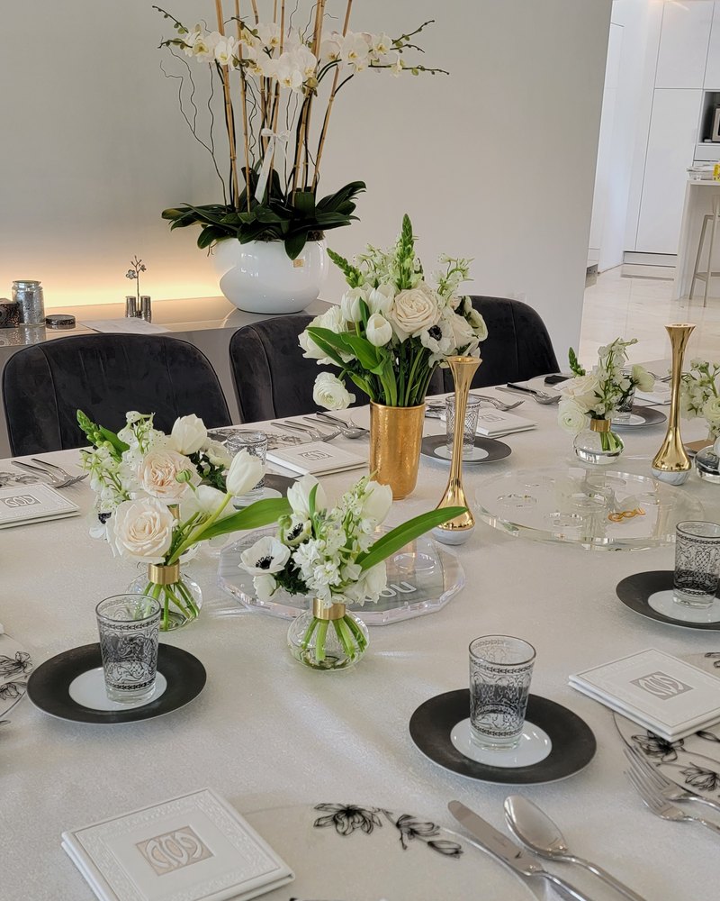 Holiday table with white lilies and roses in gold vases