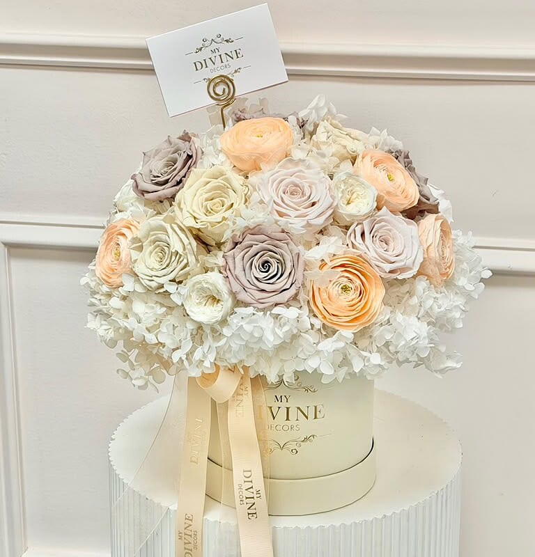 Preserved roses and hydrangea in ivory, champagne and blush tones in a cream box