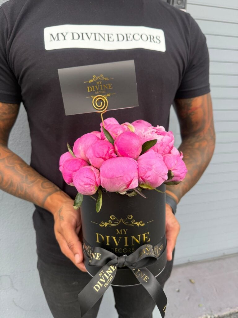 Caja sombrero mediana negra con peonías rosadas, sostenida por nuestro equipo de My Divine Decors