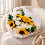 Roses and Sunflowers Hand Bouquet with white roses on an ivory boucle chair