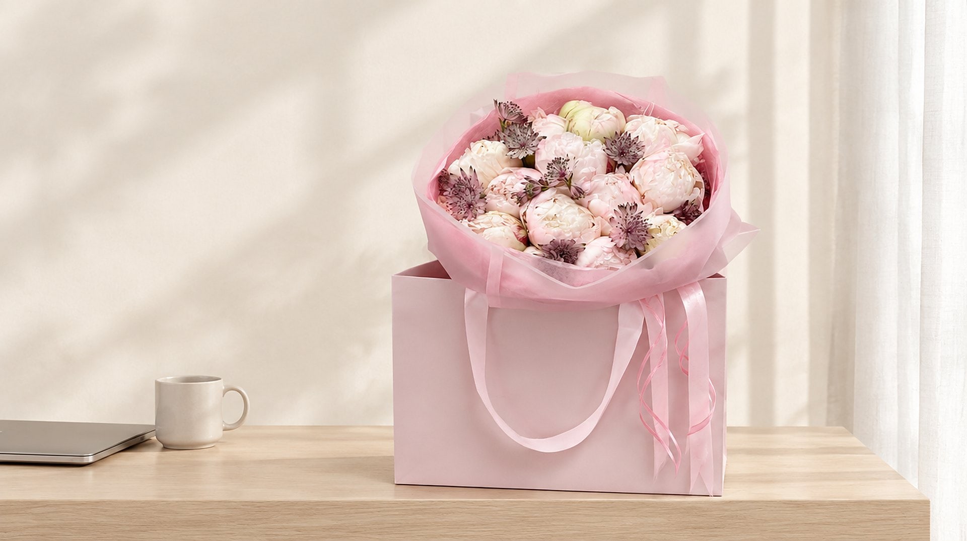 Pink peony bouquet in a signature gift bag on an office reception counter in Miami