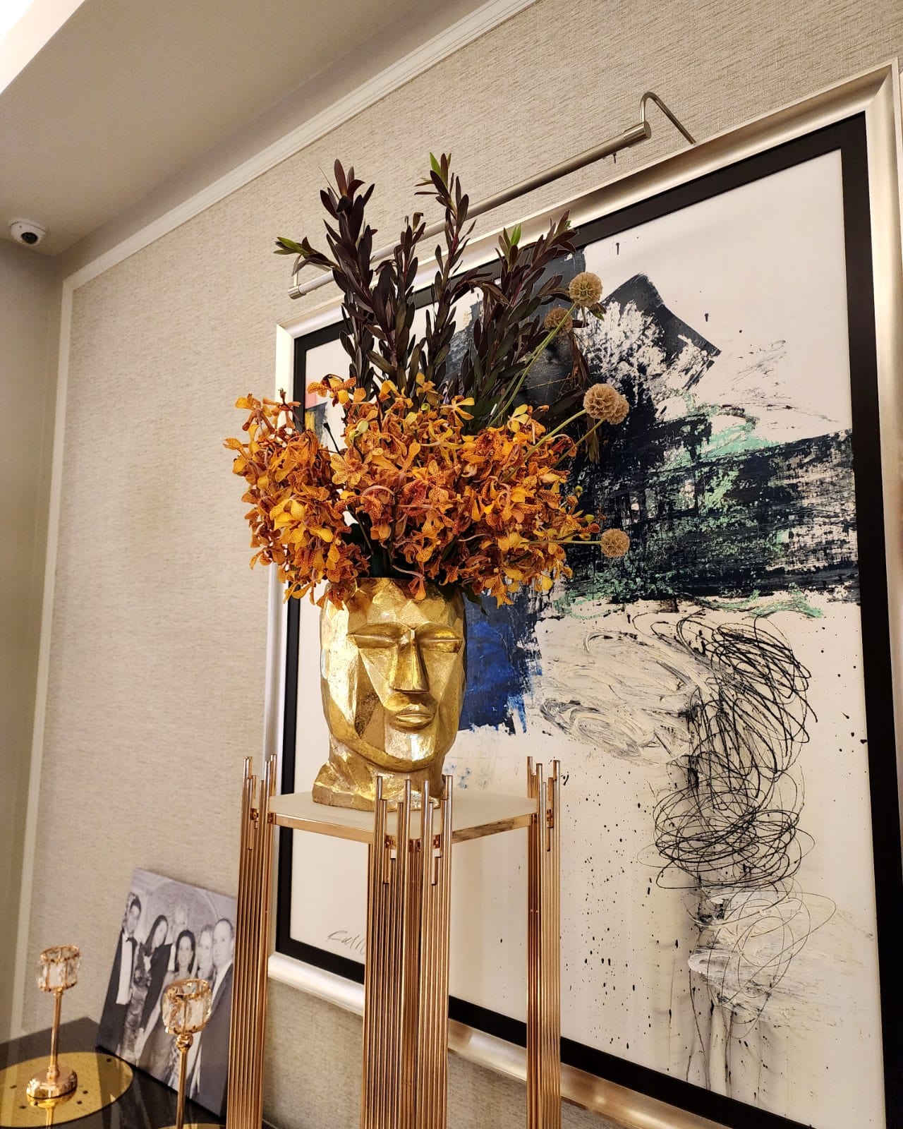 Autumn orchids and leaves in a gold face vase arranged by My Divine Decors for a Miami lobby at Thanksgiving