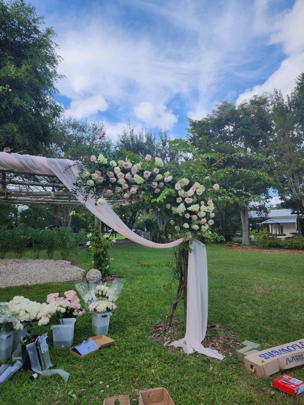 White floral wedding arch at a garden ceremony
