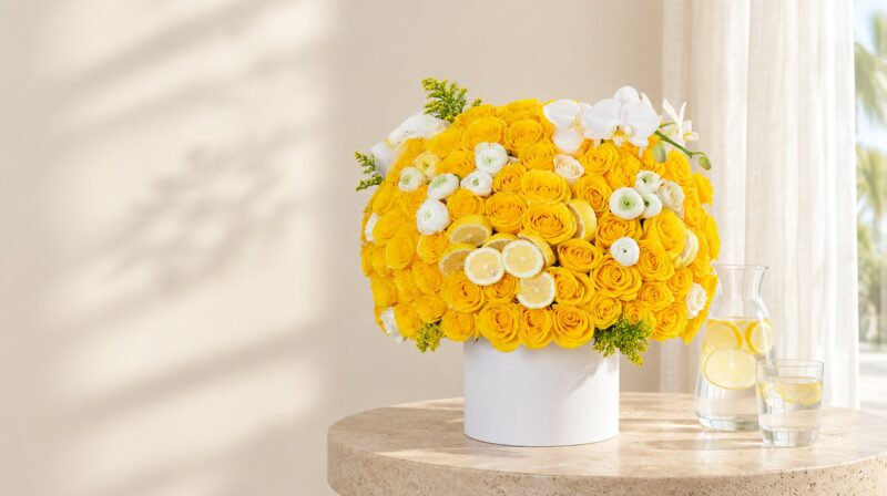 Limoncello Luxe hat box of yellow roses, ranunculus, orchids and lemon slices in a bright Miami living room