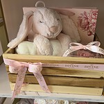 Wooden baby crate with blush bunny plush, cream blanket and pink preserved rose