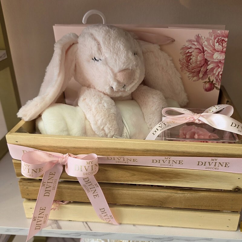 Wooden baby crate with blush bunny plush, cream blanket and pink preserved rose