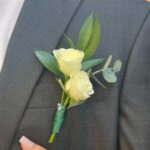 Boutonniere of ivory spray roses and eucalyptus on a gray suit lapel, by My Divine Decors in Miami