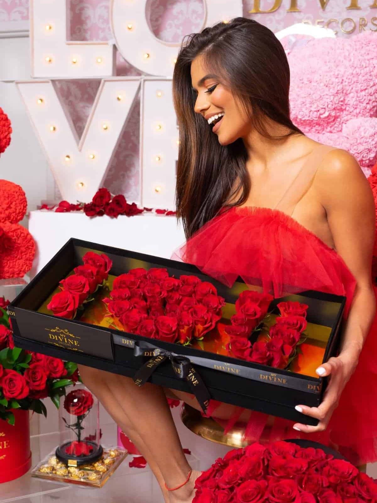 Mujer con vestido rojo de tul sonriendo ante la Caja I Love U de rosas rojas frescas de My Divine Decors