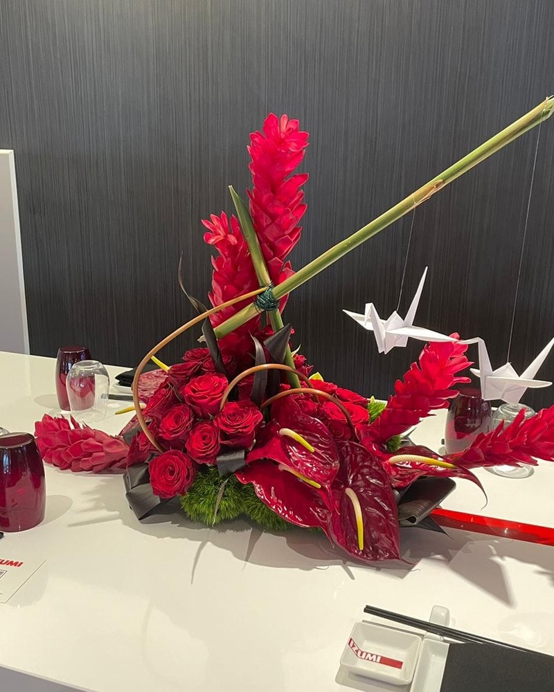 Red anthurium and ginger ikebana arrangement on a boardroom table