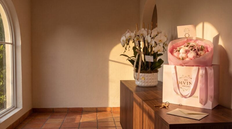 Un ramo de peonías rosadas en la bolsa Signature de My Divine Decors y una maceta de orquídeas phalaenopsis blancas sobre la consola del recibidor de una casa de Coral Gables a la hora dorada