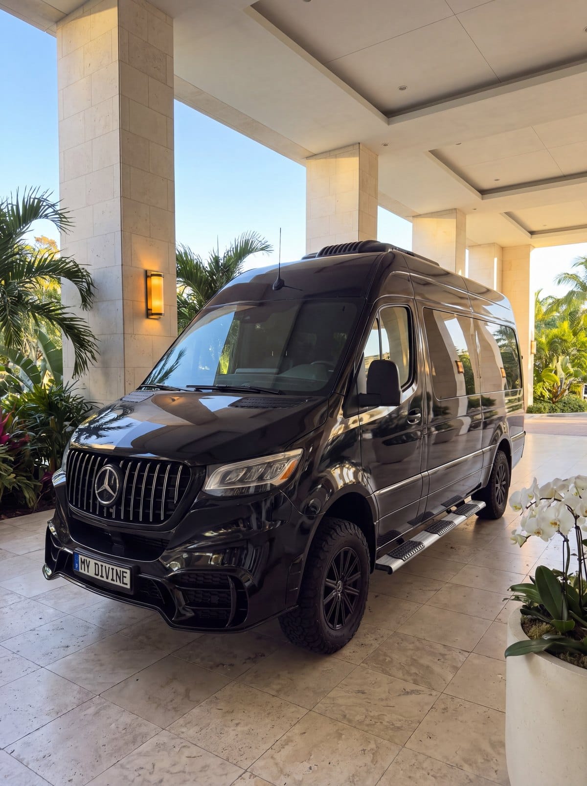 Black My Divine Decors Mercedes delivery van with MY DIVINE plate under a hotel entrance canopy