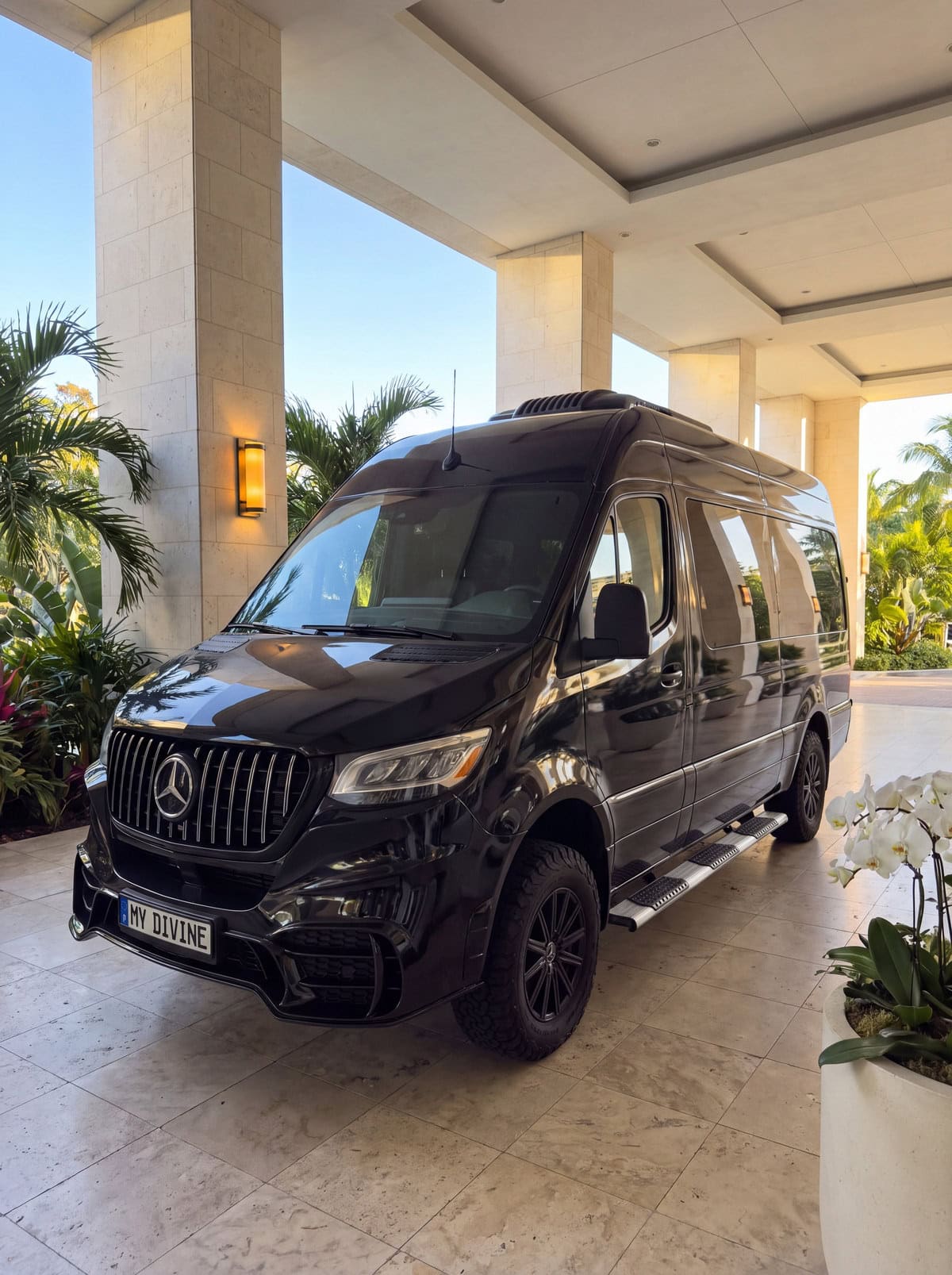Black My Divine Decors Mercedes delivery van with MY DIVINE plate at a Miami Beach hotel entrance