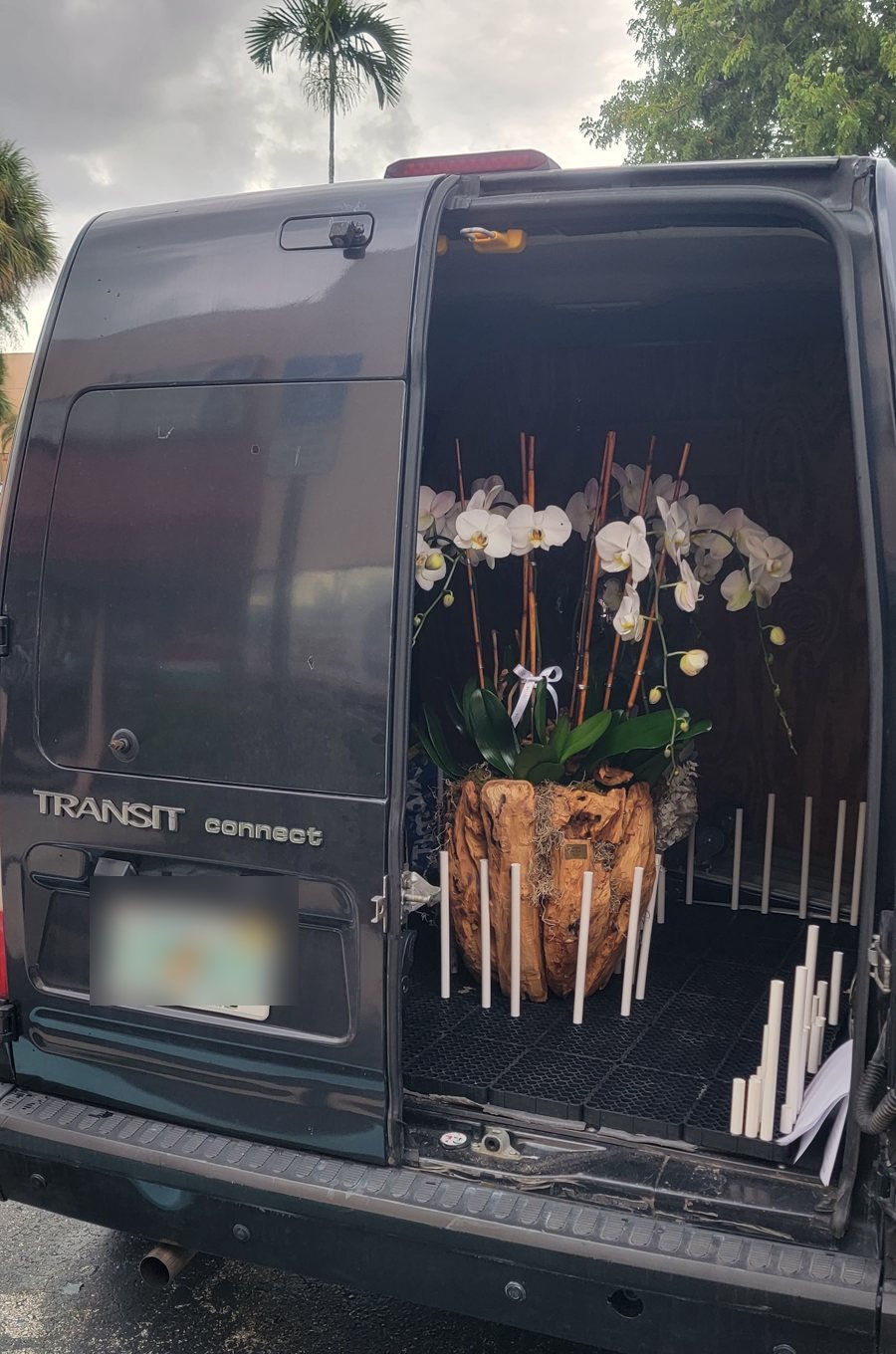 Furgoneta de My Divine Decors con arreglos de orquídeas blancas lista para salir del taller de Doral