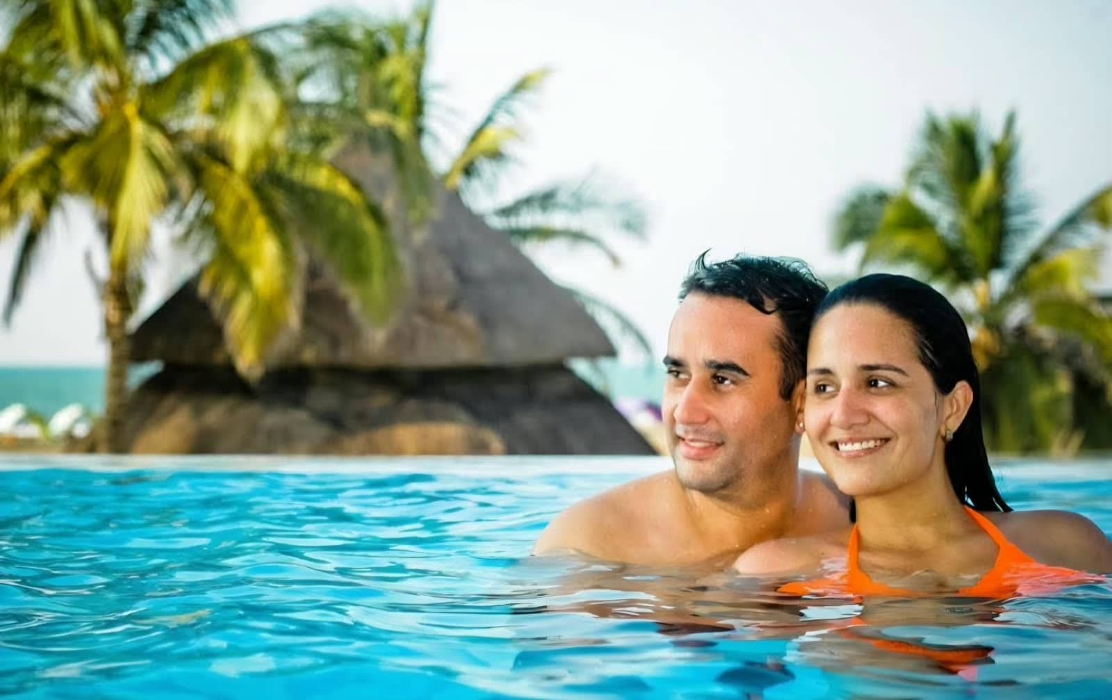 Jessica and Nelson, founders of My Divine Decors, together in a pool by the sea