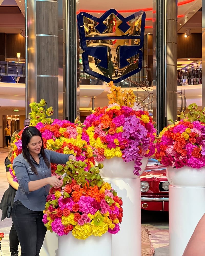 Jessica Nunez of My Divine Decors arranging flower columns under the Royal Caribbean crown