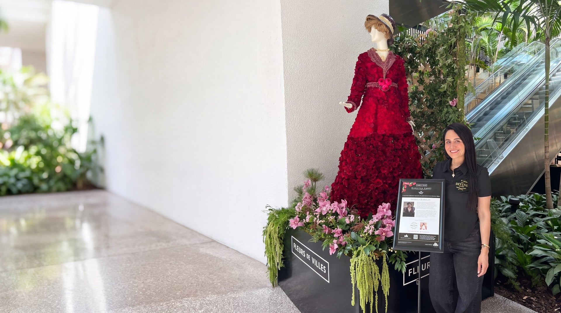 Isobel Crawley figure in a coat of red roses over an orchid planter, made by My Divine Decors for Fleurs de Villes Downton Abbey at Bal Harbour Shops, Miami, with our designer beside it
