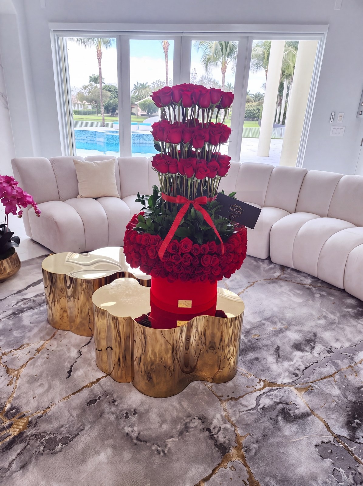 Torre de rosas rojas de My Divine Decors en una caja de terciopelo rojo en una sala frente a la piscina en Miami