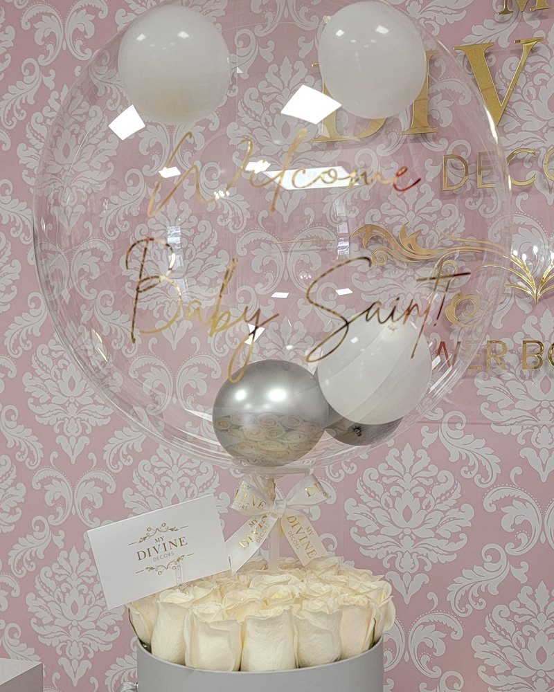 Globo personalizado sobre un arreglo de rosas blancas