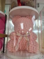 Osito pom pom rosado con cinta marfil My Divine Decors en cilindro transparente