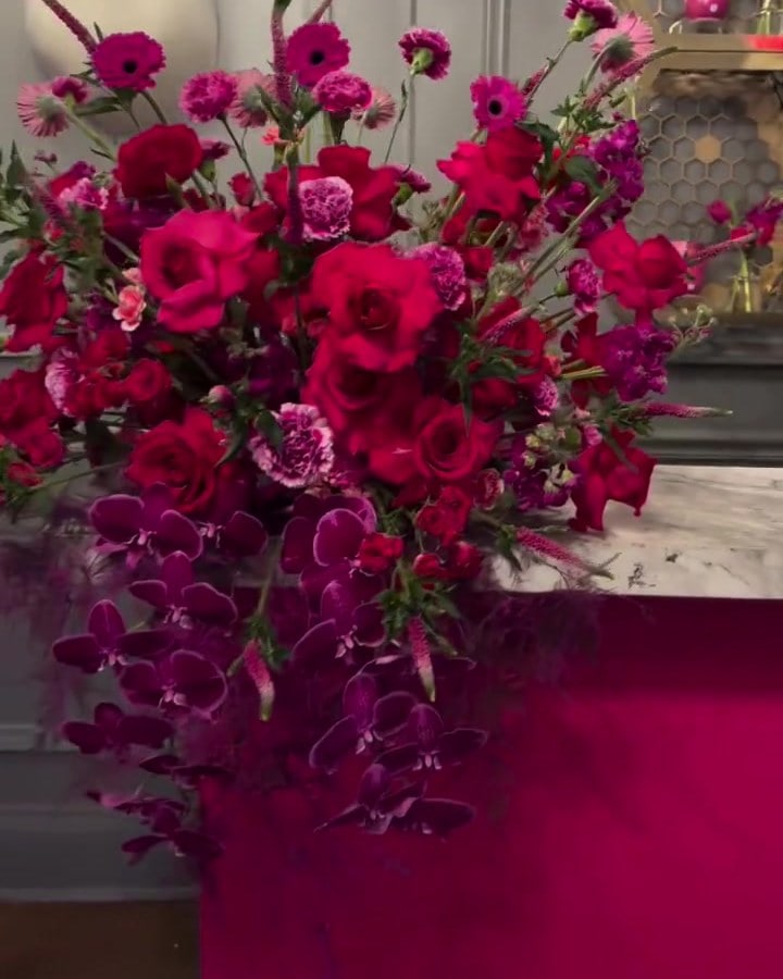 Red roses, carnations and cascading magenta orchids on a marble bar during Premio Lo Nuestro 2026