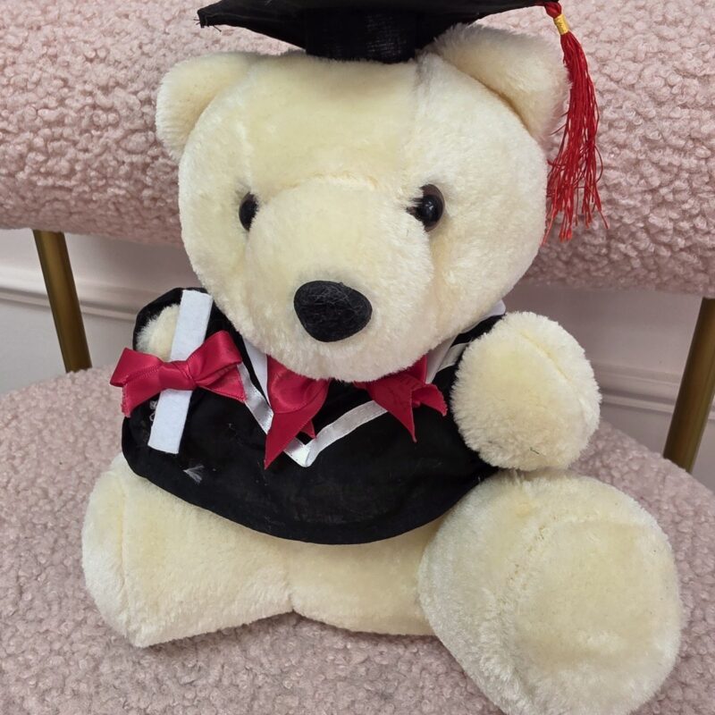 Osito de peluche crema graduado con birrete y toga negra, borla roja y diploma